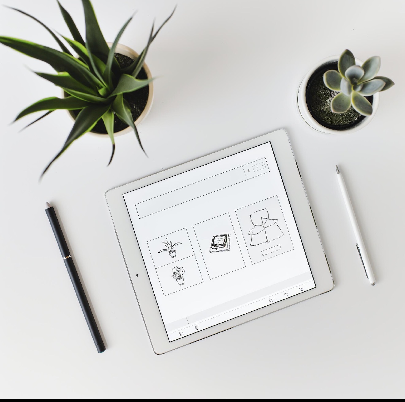 A calm workspace with plants and a tablet showing plans
